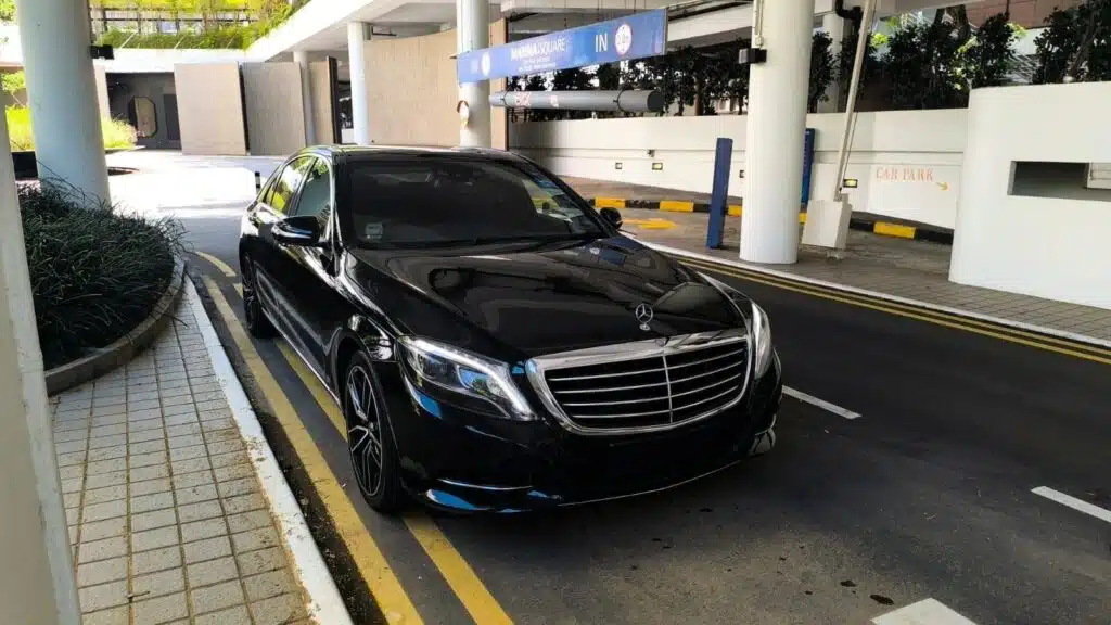 Black Mercedes S-Class sedan parked outside Marina Square for a 4 AM airport transfer Singapore
