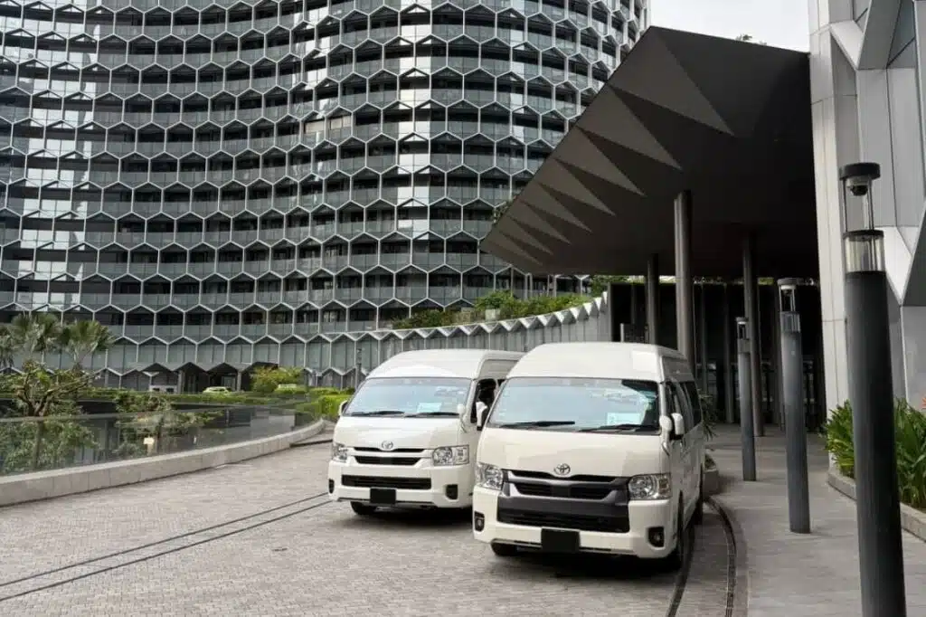 Two white vans parked at a hotel entrance during the Singapore Grand Prix Road closures 2026 guide period