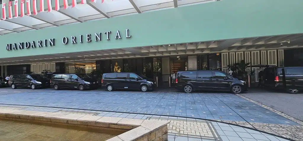 A fleet of black private vans lined up outside Mandarin Oriental, supporting the 4-Hour Singapore Guide for Cruise & Layover Visitors